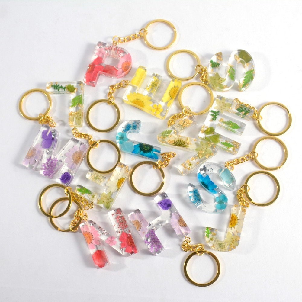 4d resin flower keyring keychain . Initial letters handmade in green , yellow , blue , pink , purple , clear. Featuring a gold strong durable chain. A-Z letters available for all initials. In the photo is afew of each colour and letter.